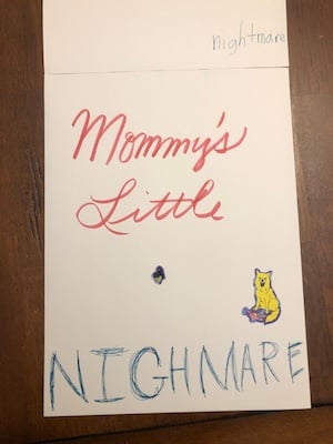 a piece of paper that reads Mommy's Little in cursive, then NIGHMARE (sic) underneath. There's a yellow sticker of a dog. Near the top of the image the word "nightmare" is also written.
