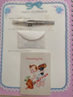 a Baby Keepssakes page with a hospital bracelet, a lock of hair, and a birth announcement