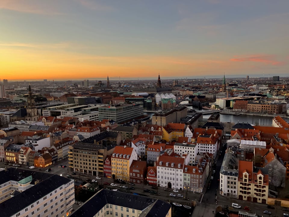 City roofs under a sunset sky.