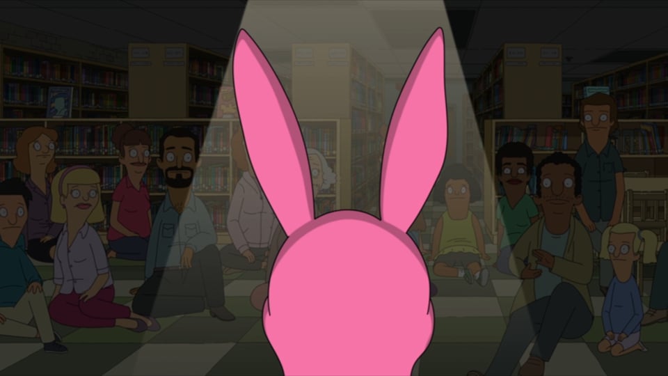Bob's Burgers screenshot of Louise looking out at a dimmed audience in the library, the back of her pink bunny ears hat visible in a spotlight.