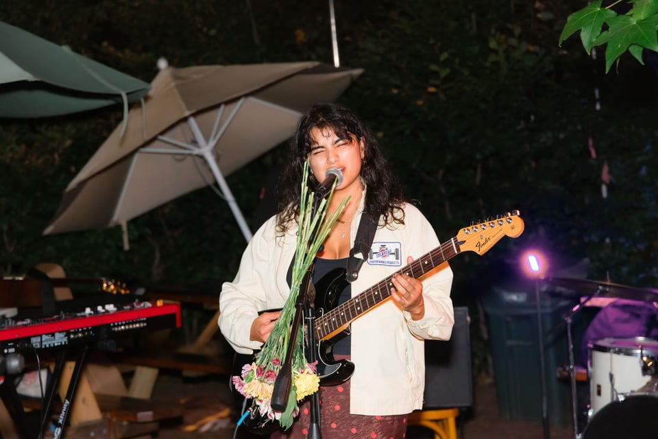 Maushi plays guitar and sings