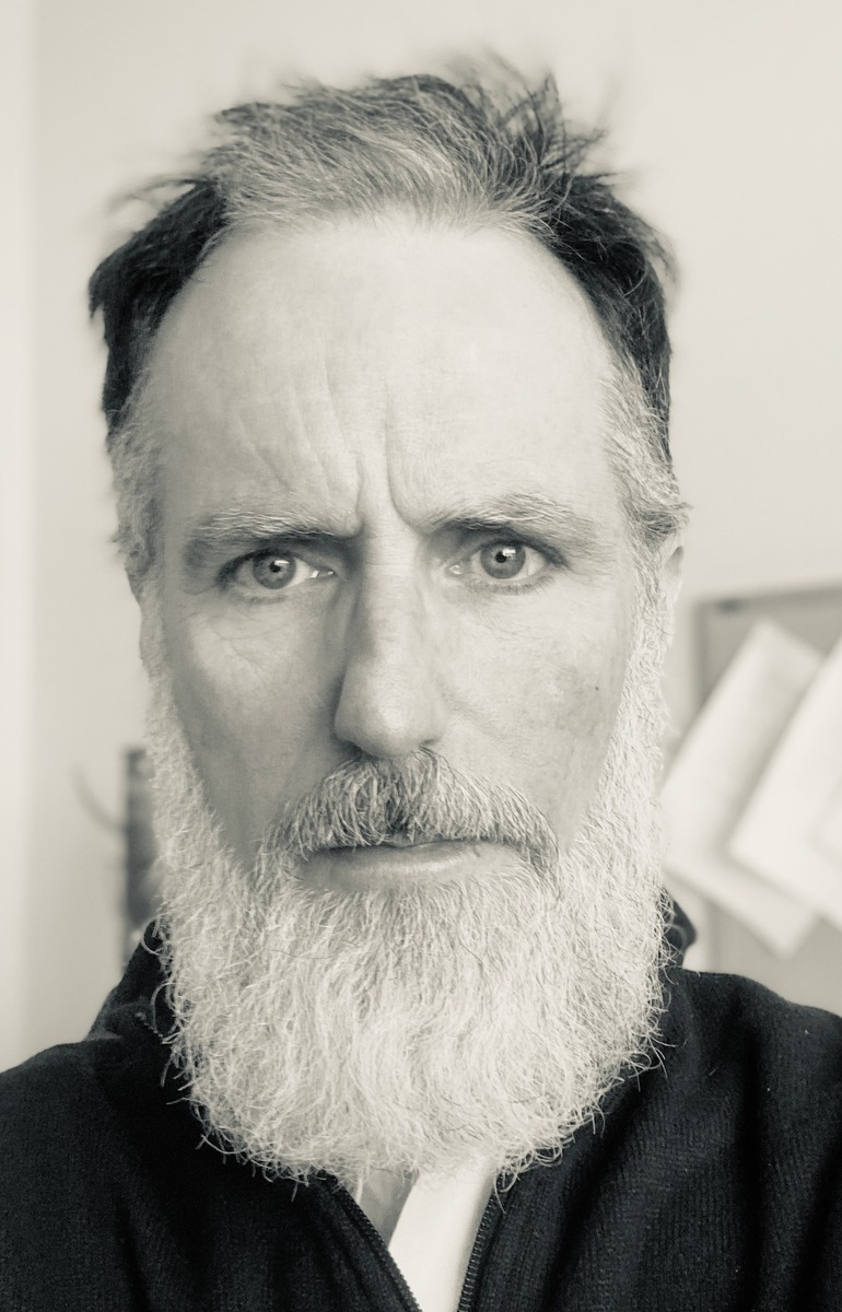 A sepia-toned portrait of Connecticut musician Ken Cormier, sporting an impressive white beard.