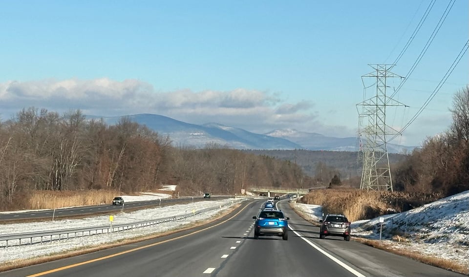 photo through a car windshield of the New York Thruway with the Catskill Mountains in the distance
