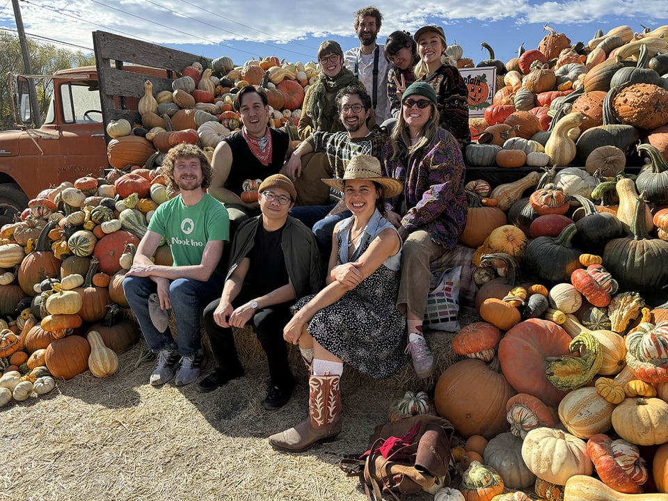 A group of friends amongst pumpkins.
