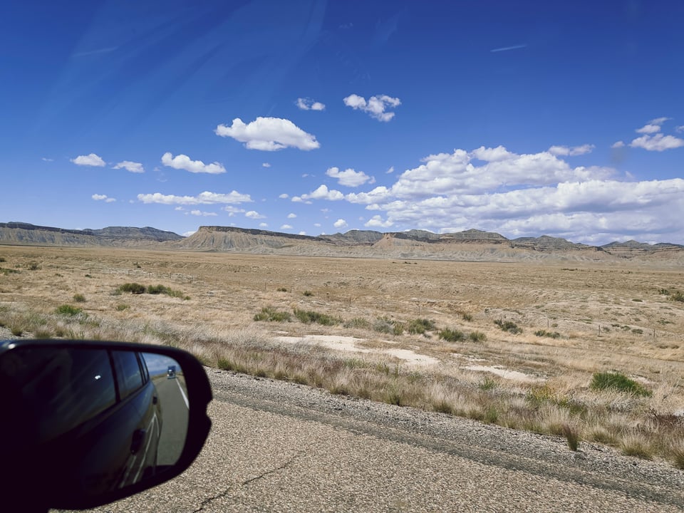 A view of Utah or Arizona, with vaguely-car-shaped hills in the background.