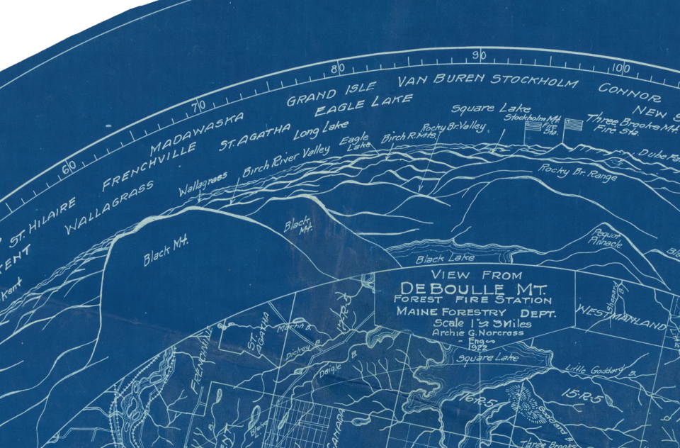A close the round blue map, out nearer the curved edge of the circle, showing a Vista of hills -- with names like "Black Mt" -- and, up closer, a network of rivers and lakes. There is a label: "View from Deboulle Mt, Forest Fire Stration, Maine Forestry Dept." The map is dark blue and all the drawing is white and clearly drawn by hand, it is quite beautiful