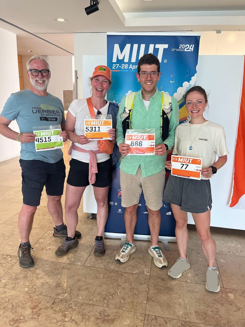 Four people, Jos, Noortje, Adam, and Kelsey standing in front of a banner for the Madeira Island Ultra Trail event.