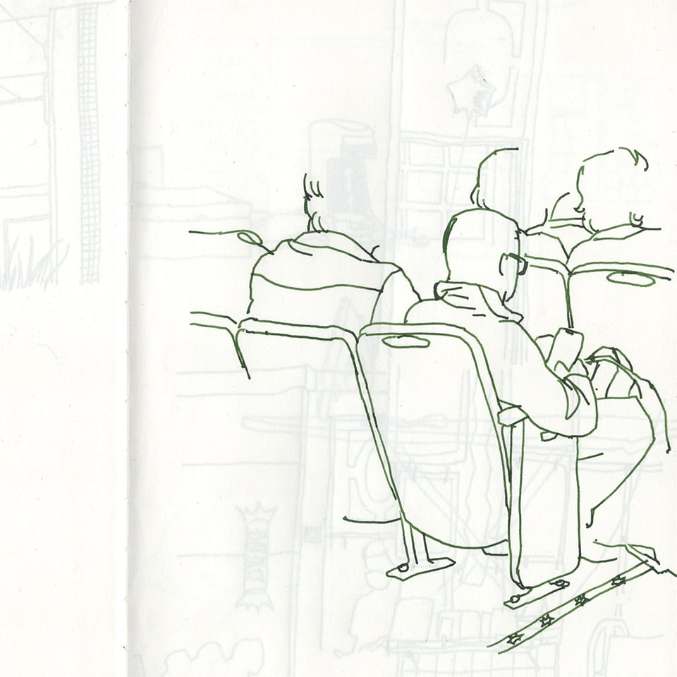 fountain pen sketch of theater seats with someone looking at their phone in green ink