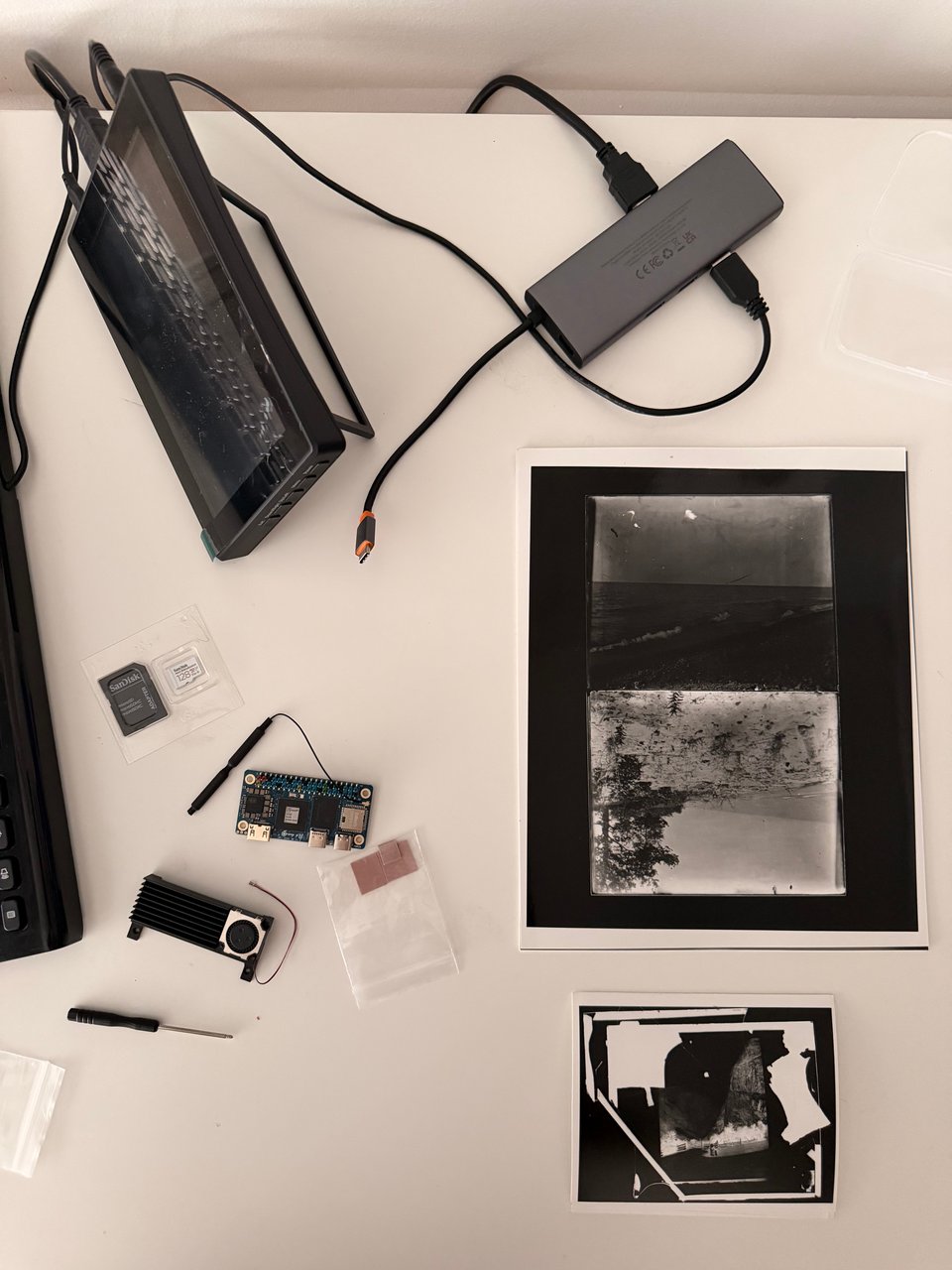 a desk with silver gelatin prints and cyber deck