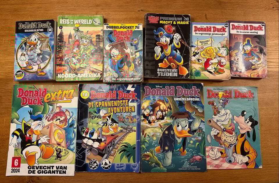 Ten Donald Duck comic books are lined up on a table in two rows.