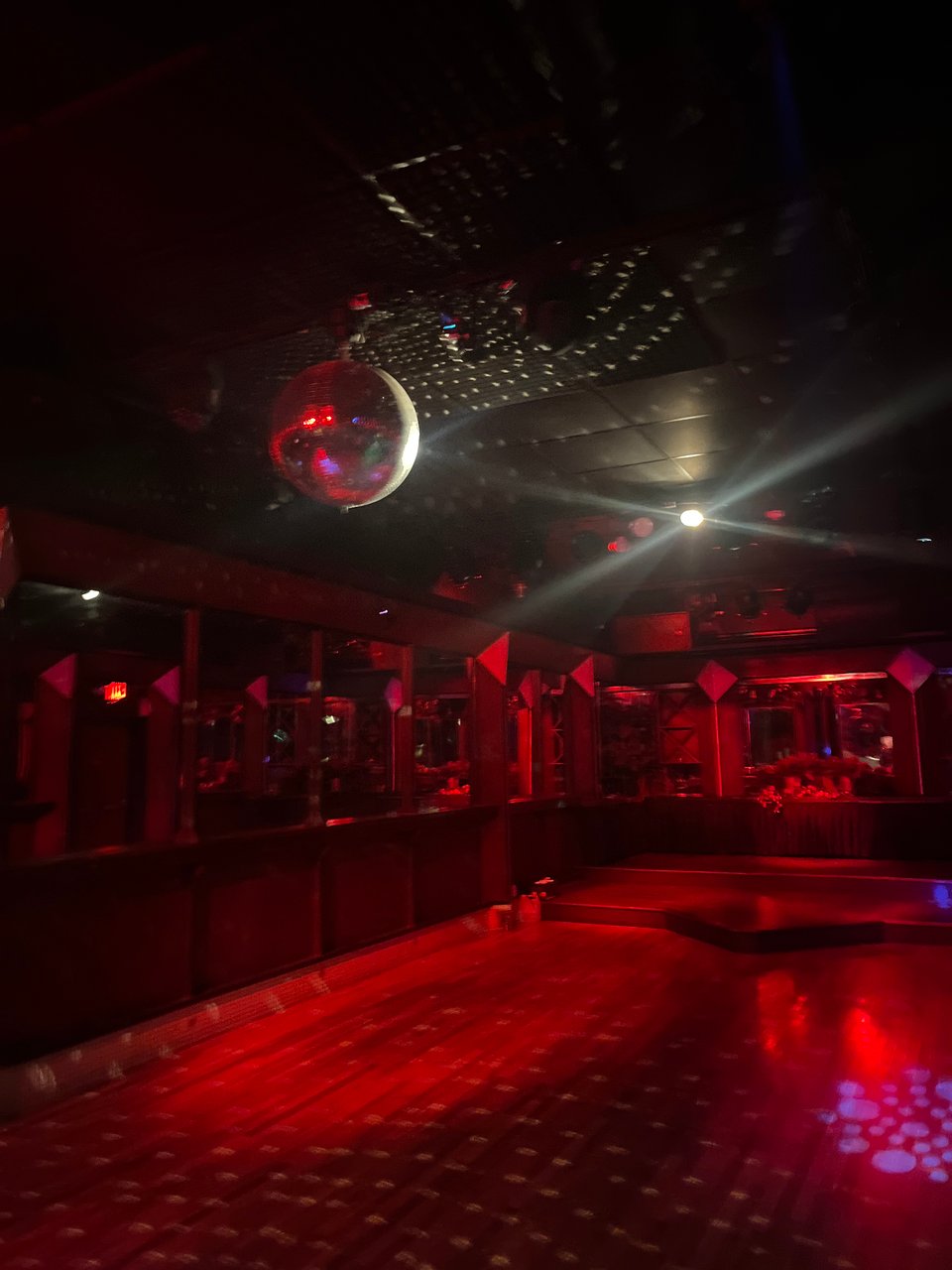 disco ball over a red-lit empty dance floor