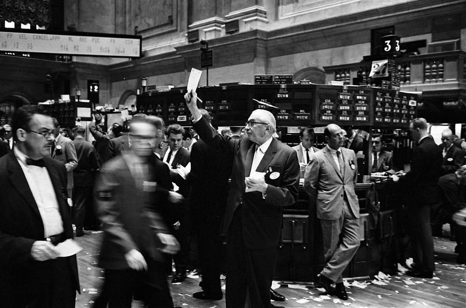 Stock brokers working at the New York Stock Exchange (NYSE) trading floor, 1963.  Photo by Thomas J. O'Halloran, via U.S. News & World Report.  Downloaded from Wikimedia Commons, which marks the image as in the public domain.
