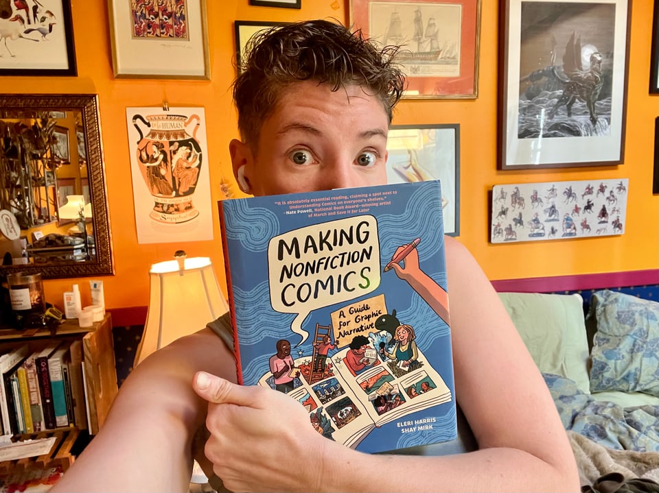 Lucy holding a copy of Making Nonfiction Comics.