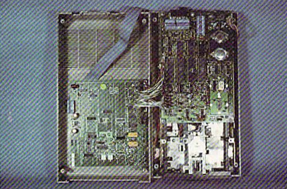 A disassembled 1541 drive on the right with an attached "DOS" card from Mimic Systems on the left. There are several jumper cables connecting the two cards.