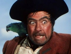 Long John Silver as played by Robert Newton, a pirate, with a pirate's hat and a pirate's polly and a mad, goggle-eyed stare.