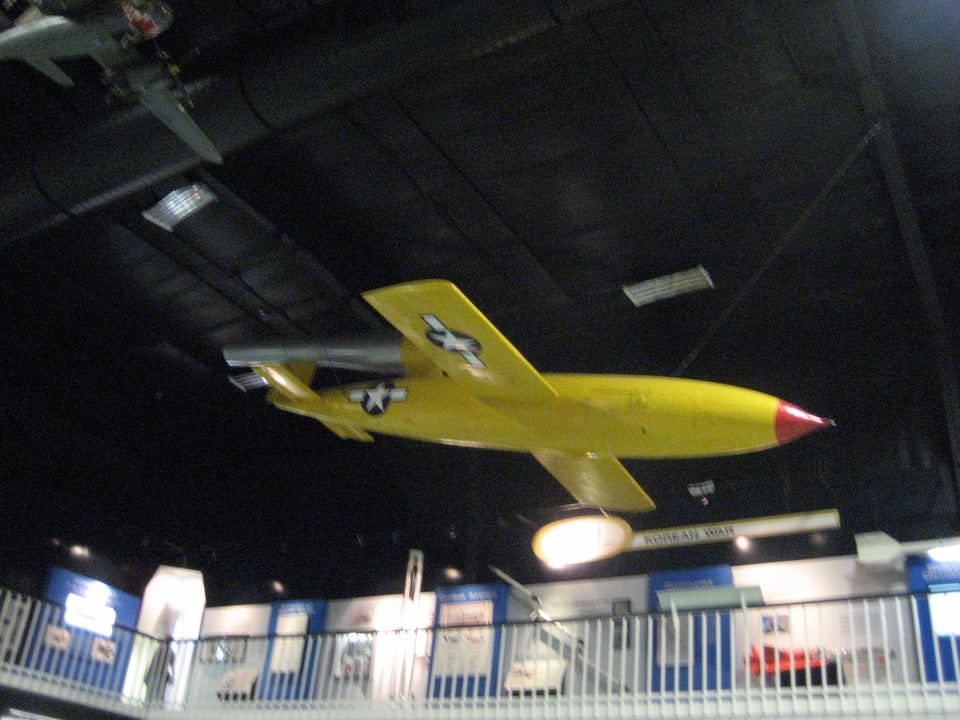 A yellow plane with short wings and no visible engine. It has a red tip and stars on the wings and rear fuselage.