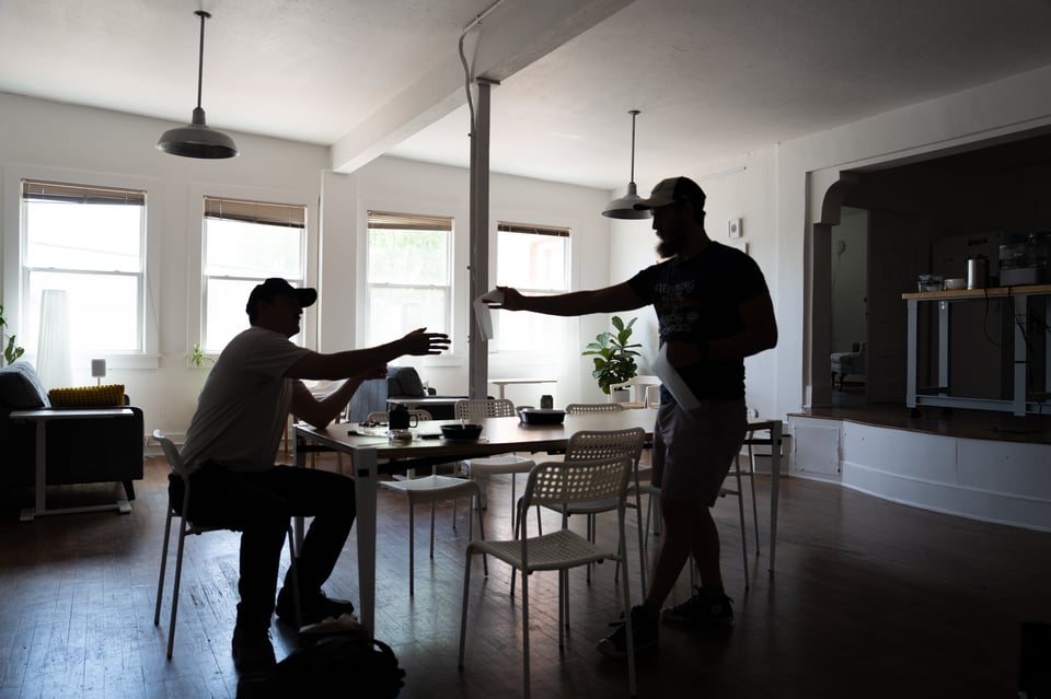 Alex handing Mike a paper towel.