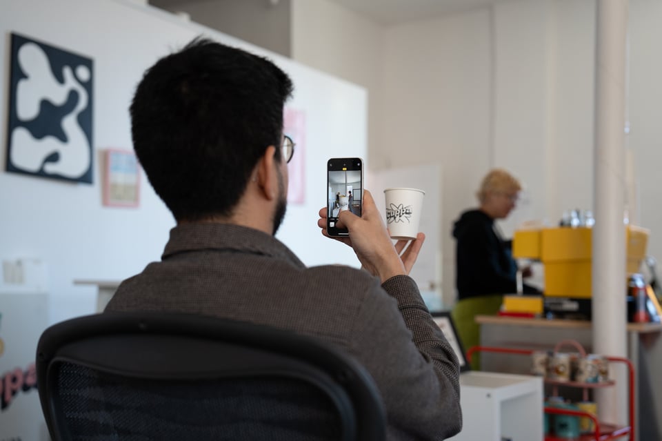 Justin taking a photo of a cup.