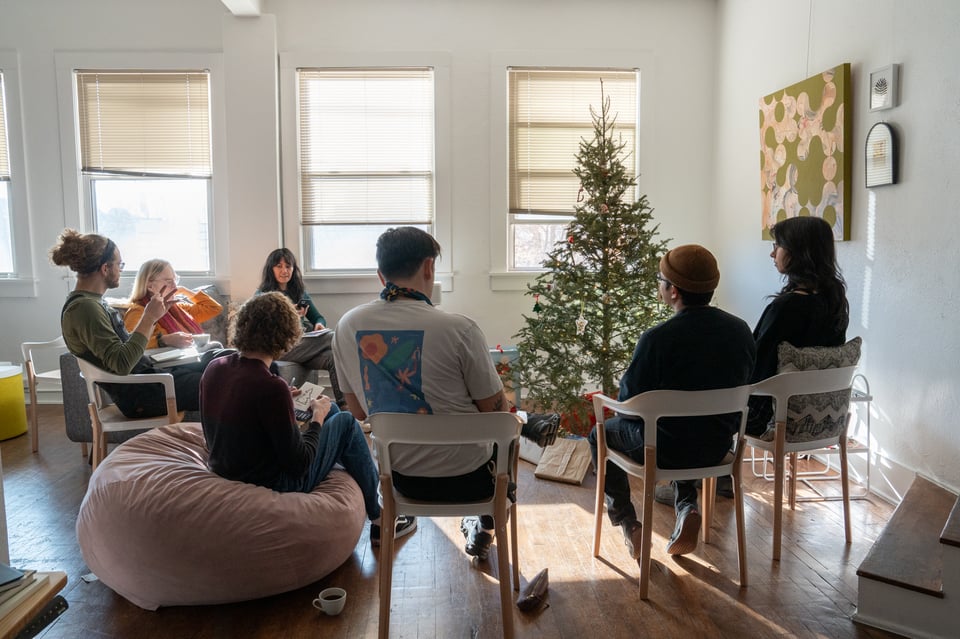 A group gathered around a Christmas tree.