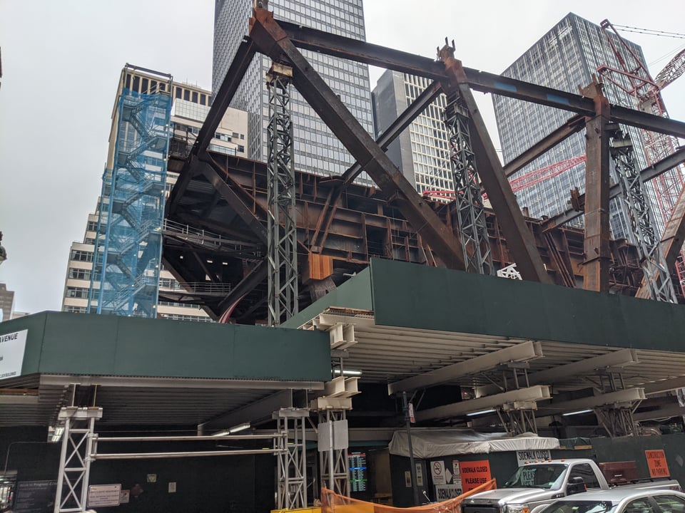 A building under construction with massive girders reaching into the sky