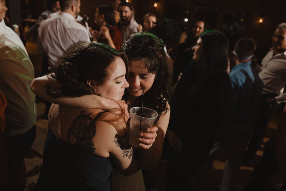two women hugging at a wedding reception