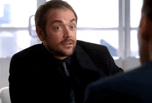 A gif from the show Supernatural. The demon Crowley takes out a scroll from his suit and it unrolls into a ridiculously long contract.