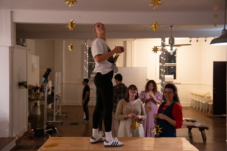 Halie standing on a table hanging up stars.