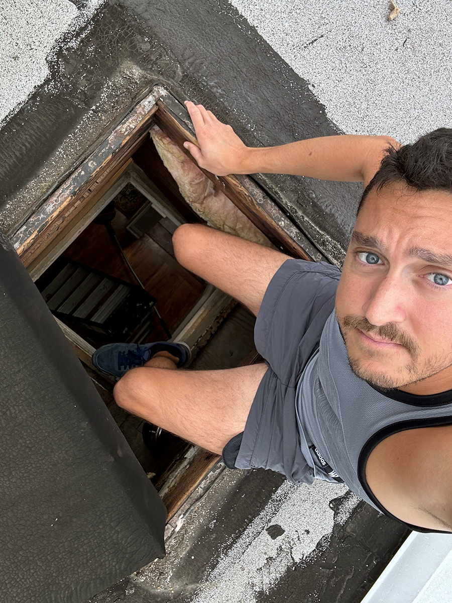 The author sitting on the edge of a roof hatch.