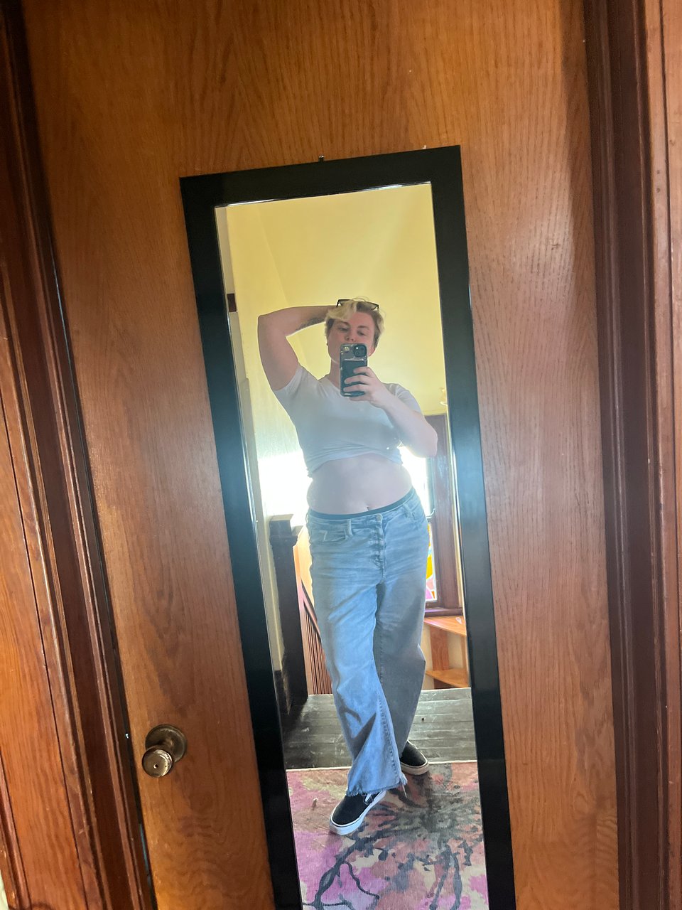 Nola getting ahead of herself with a spring-y outfit - tight white crop tee, baggy light wash jeans, Vans, sunglasses perched over bleached blonde hair swoop