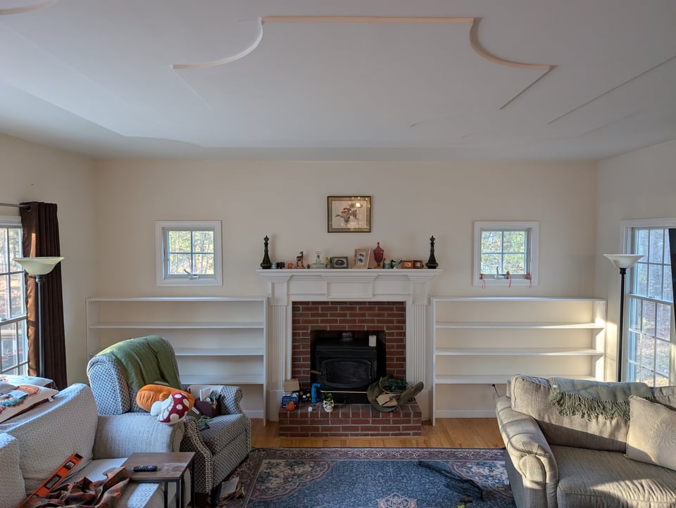 A living room with white built-in bookshelves to either side of the fireplace.