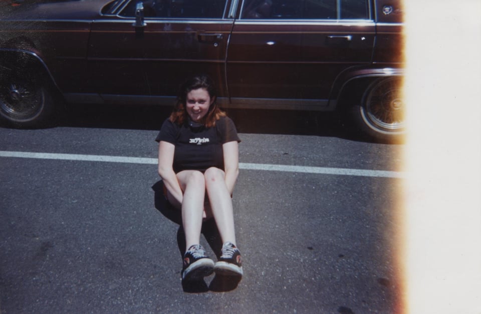 Katherine with long legs in a parking lot.