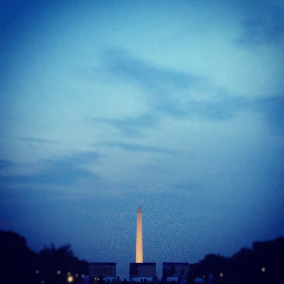 A blurry photo of the Washington Monument, with lots of blue sky/clouds.
