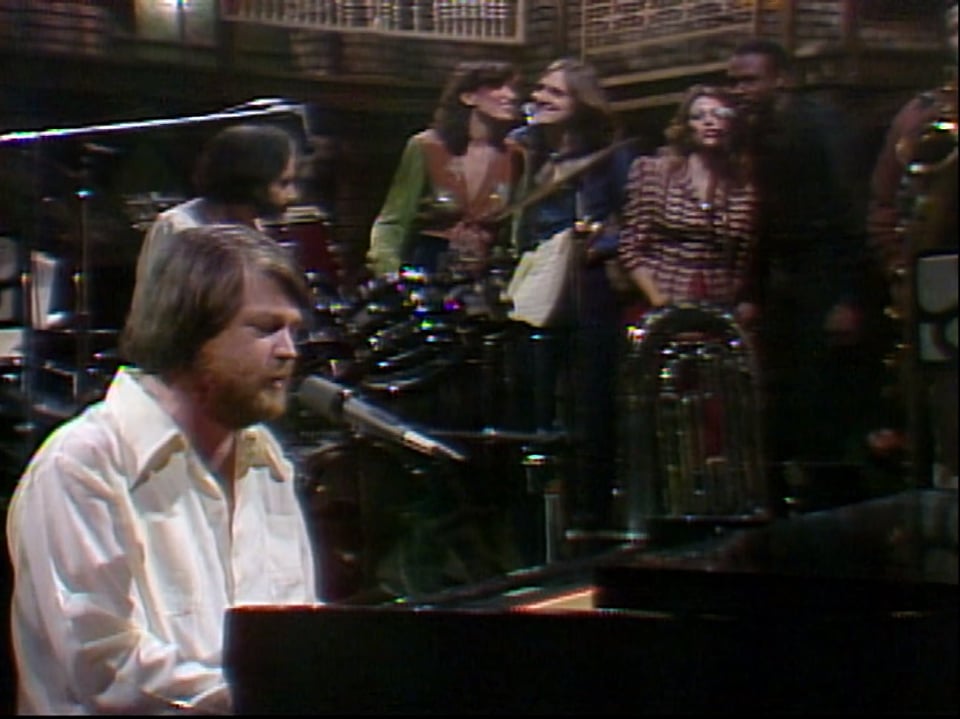 a man playing a piano in front of a group of people