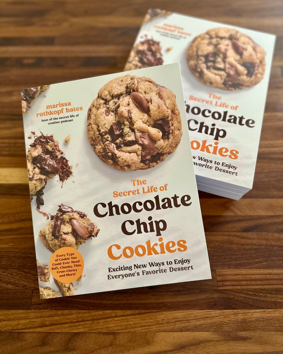 photo of a stack of copies of the book, The Secret life of Chocolate Chip Cookies, on a wooden table.