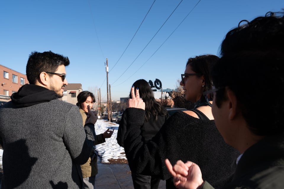 A group walking and holding their hands in their air.