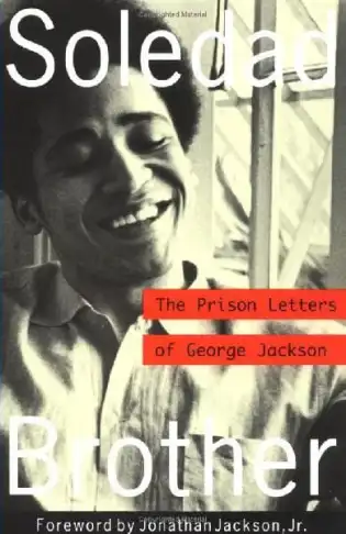 Photo of the front cover of 'Soledad Brother: The Prison Letters of George Jackson', has a black and white picture of a smiling Black man with a small afro haircut, next to what appears to be a barred window. The foreword is by Jonathan Jackson Jr.