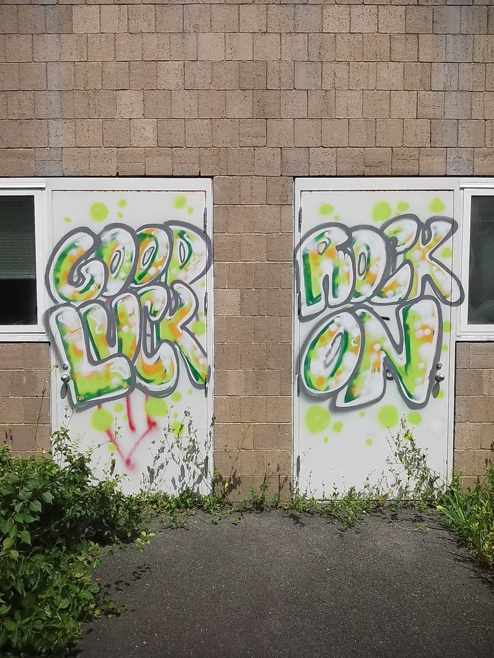 digital Instax image of a pair of white doors outside a building, with greenish graffiti reading, "GOOD LUCK ROCK ON" on them
