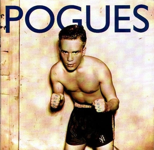 A sepia-toned photo of a young white boxer, facing the camera, in boxing pose but no boxing gloves. He has short dark hair and wears only boxer shorts. The photo looks as if it's from the 40s or 50s. He has "Peace" and "Love" tattooed on his fingers. This means his one fist was photoshopped to add a sixth finger.