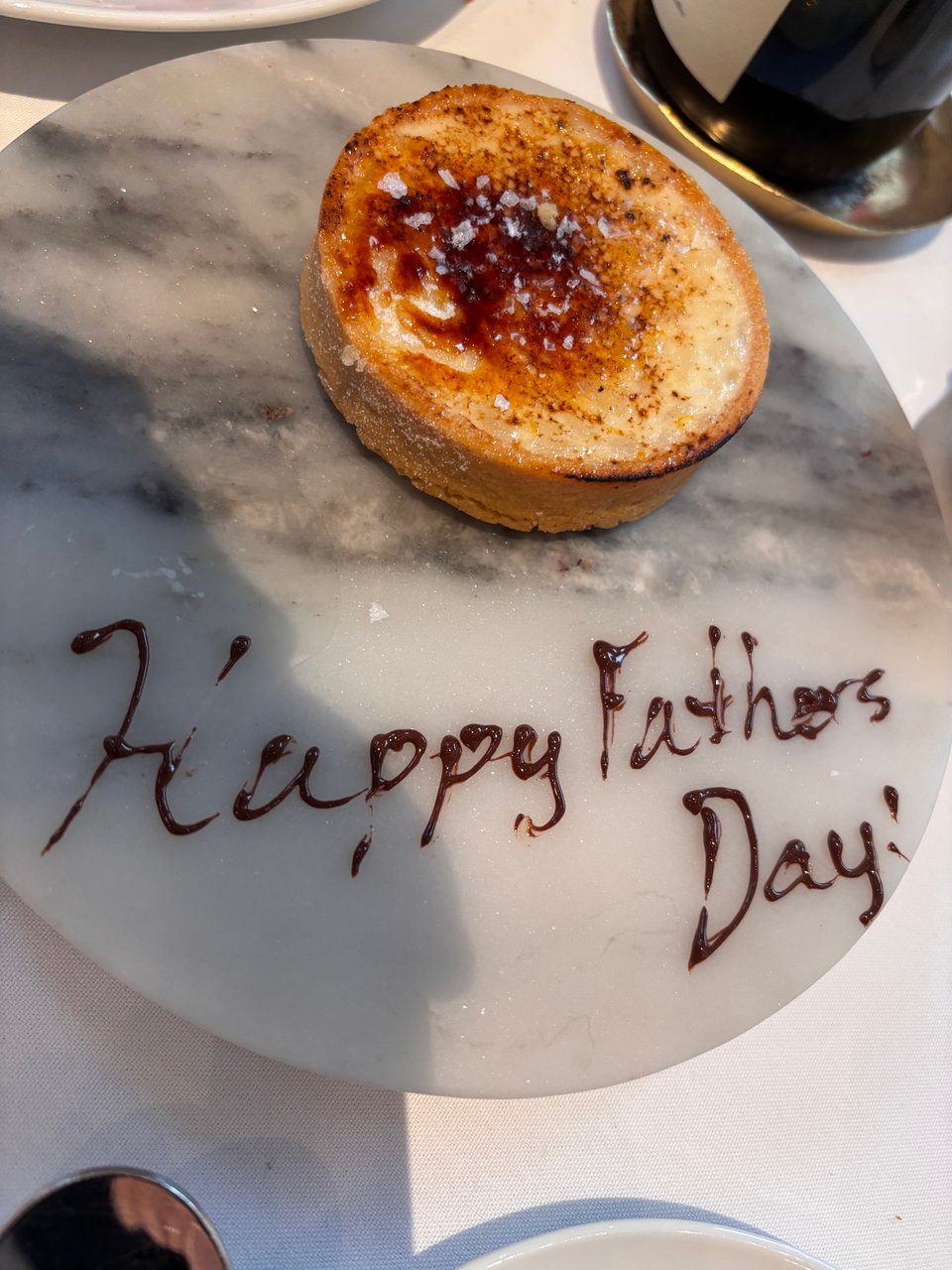 "Happy Father's Day" drizzled in chocolate on plate with cream tart at Union Square Cafe, New York City