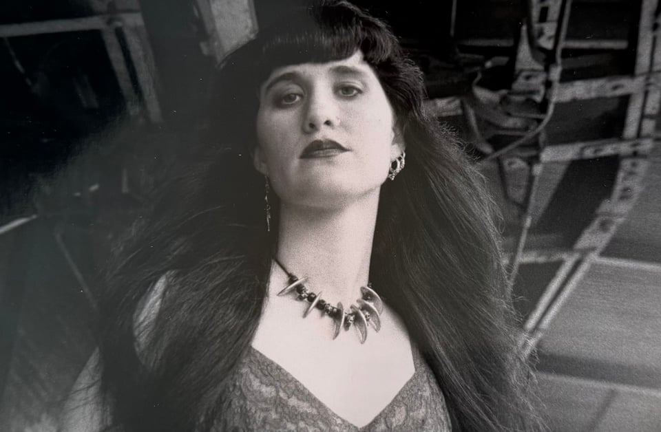 Me at 25, with long flowing black hair, smoky eyes and red lips.