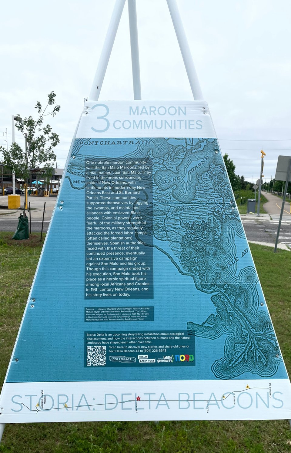 a tripod installation that reads "Maroon Communities: One notable maroon community was the San Malo Maroons, led by a man named Juan San Malo. They lived inthe areas surrounding colonial New Orleans, with settlements in modern-day New Orleans East and St. Bernard Parish. These communities supported themselves by logging the swamps, and maintained alliances with enslaved Black people. Colonial powers were fearful of the military strength of the maroons, as they regularly attacked the forced labor camps (often called plantations) themselves. Spanish authorities, faced with the threat of their continued presence, eventually led an expensive campaign against San Malo and his group. Though this campaign ended with his execution, San Malo took his place as a heroic spiritual figure among local Africans and Creoles in 19th century New Orleans, and his story lives on today.