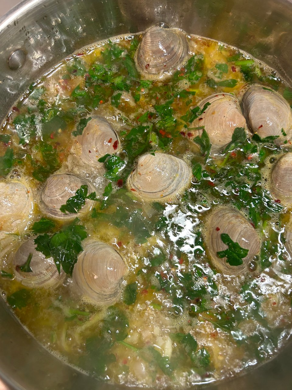 little neck clams simmering in a broth of white wine, red pepper flakers, salt, fresh parsley, garlic, & shallots.