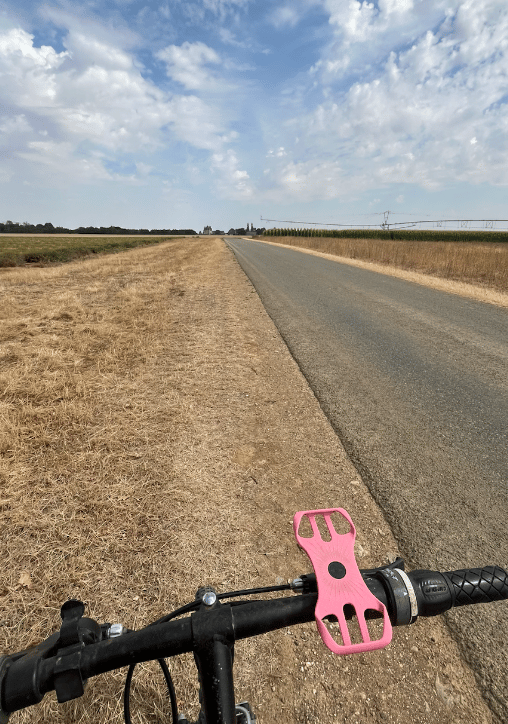 Riding a bike on a road in the middle of nowhere with fields on each side