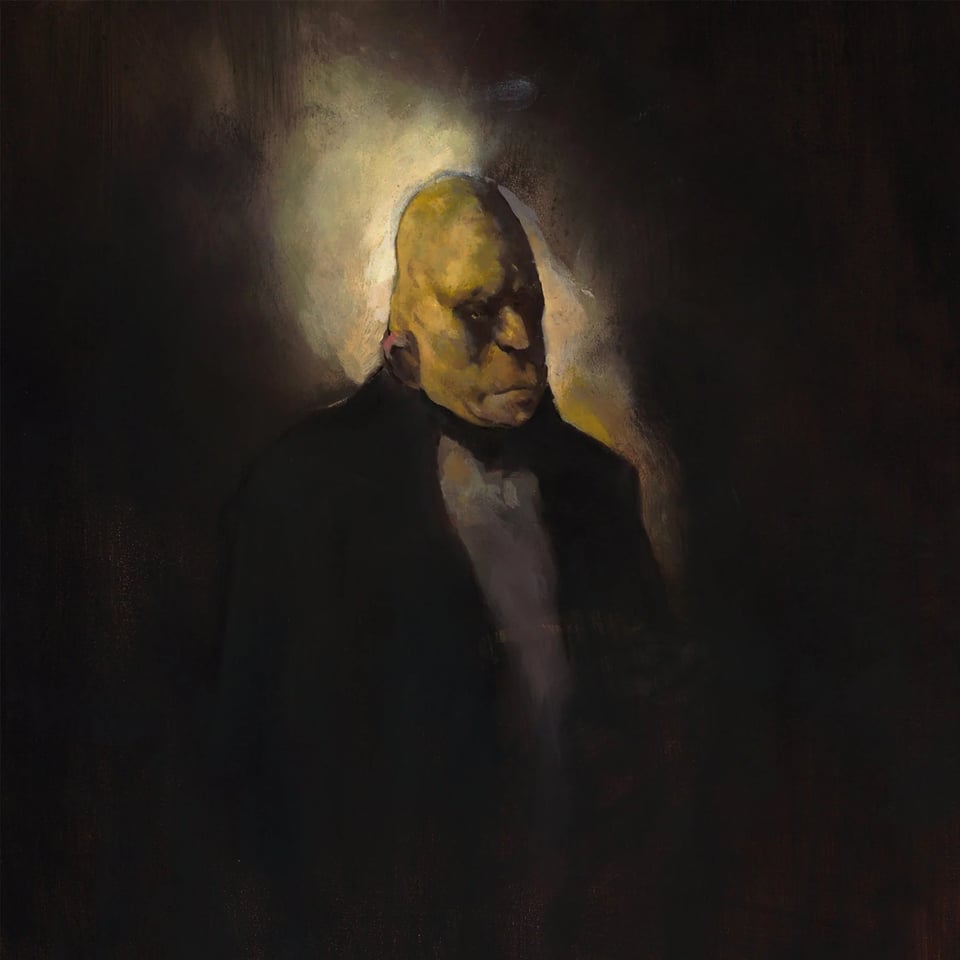 A man whose head is both pointed and flat, plastic clay like ears attached to his head by wires and scratches across his face.