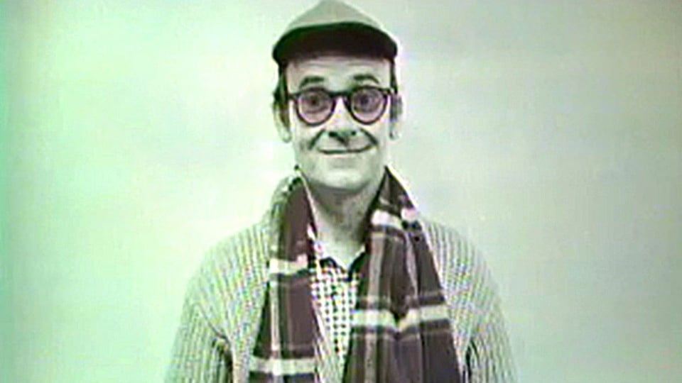a man wearing glasses and a scarf
