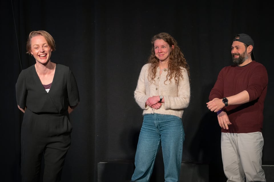 Laura presenteert een scène op het podium met 2 lachende cursisten