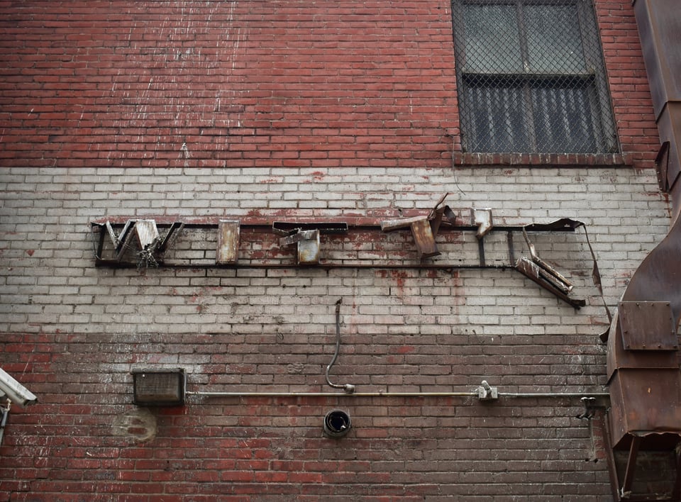 Remnants of a sign for Witt's market on a brick wall in Downtown Minneapolis