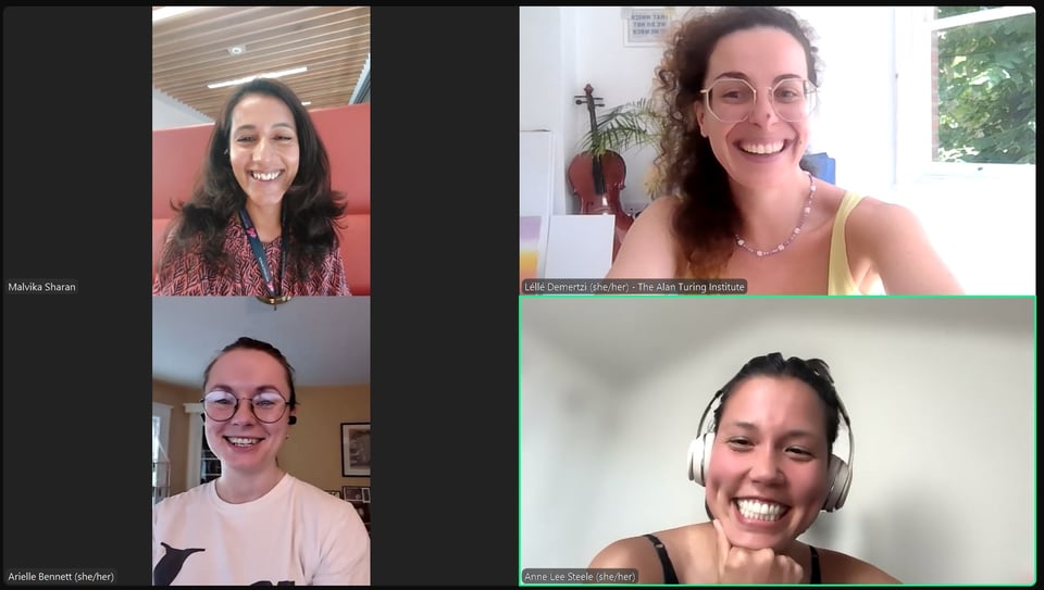 Screenshot of Malvika, Lelle, Arielle and Anne smiling. Anne is wearing white headphones with her hair up. Arielle has glasses. Malvika is wearing a lanyard and has long dark hair. Lelle has her curly hair pulled to the side with glasses.