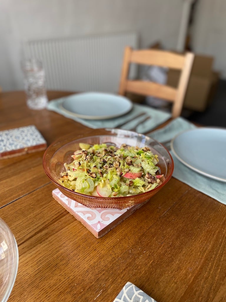 A waldorf salad in a pink bowl on a table