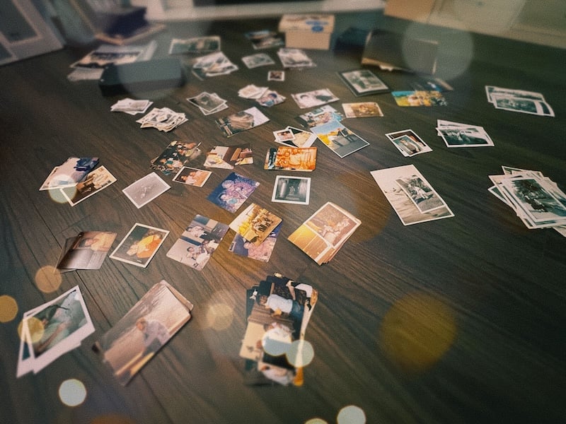 Stacks of photos on a wooden floor